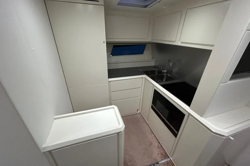  Yacht Photos Pics Modern kitchen interior on a 2020 Itama 62 yacht, featuring sleek cabinetry and appliances.