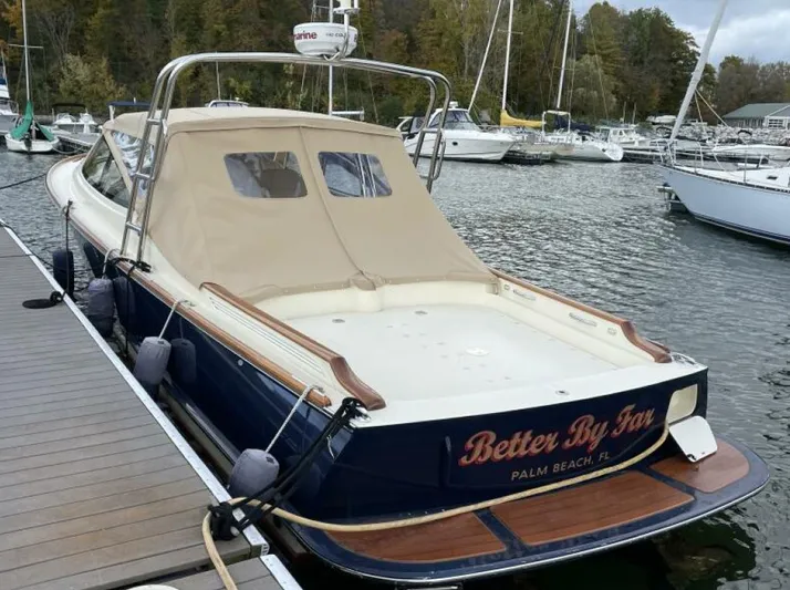 Better By Far Yacht Photos Pics 2012 Hinckley Talaria boat docked, featuring a beige canopy and wooden accents.