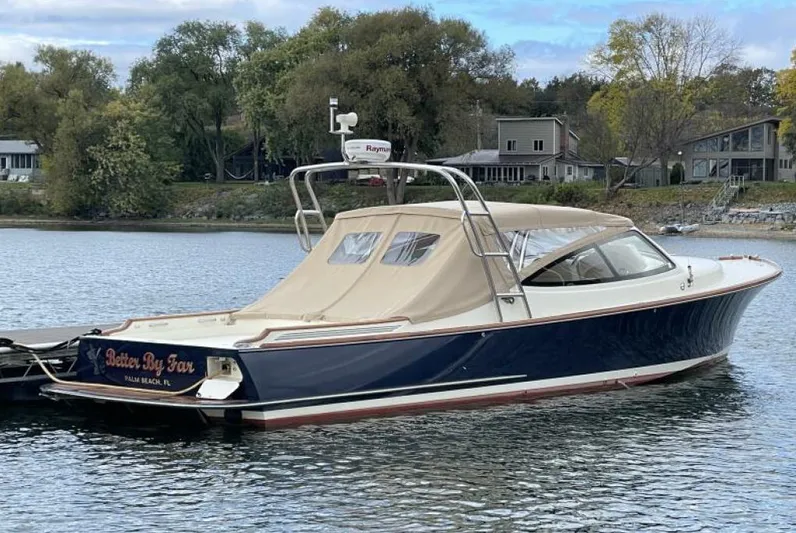 Better By Far Yacht Photos Pics 2012 Hinckley Talaria boat docked on a serene lake with surrounding trees and houses.