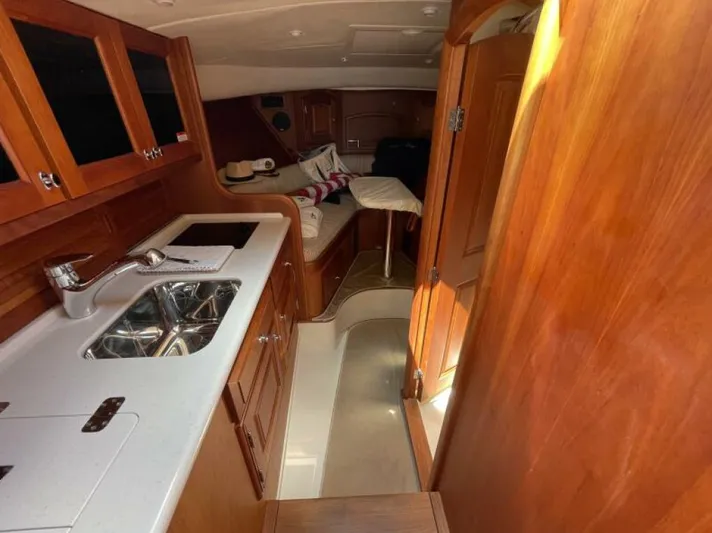 Better By Far Yacht Photos Pics Interior of 2012 Hinckley Talaria yacht with wooden cabinetry and compact kitchen area.