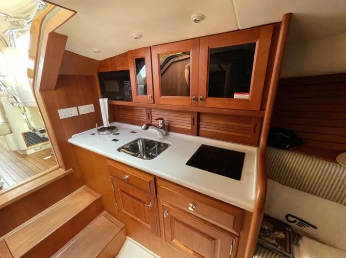 Better By Far Yacht Photos Pics Hinckley Talaria 2012 yacht interior with wooden cabinetry, sink, and stovetop.