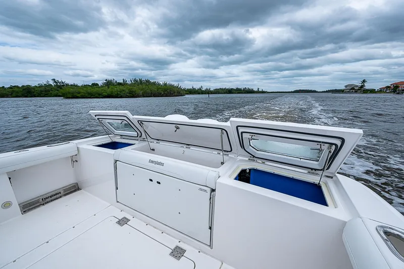 Riptide Yacht Photos Pics 2018 Everglades 435 Center Console boat on water under cloudy sky.