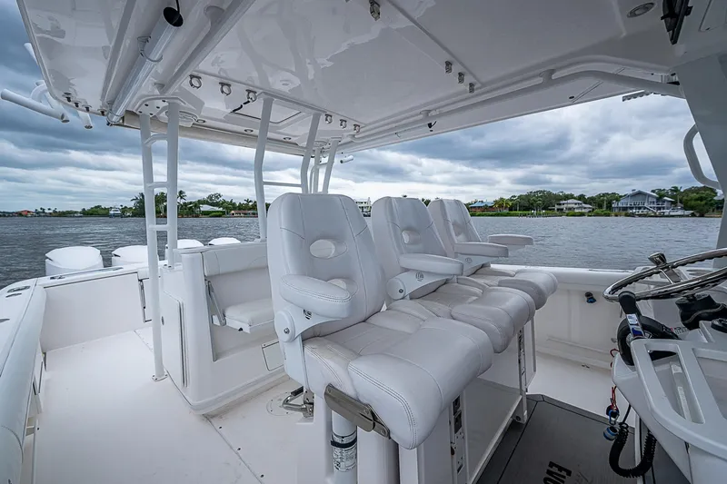 Riptide Yacht Photos Pics 2018 Everglades 435 Center Console boat with white seating, on a calm water backdrop.