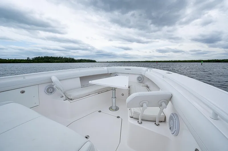 Riptide Yacht Photos Pics 2018 Everglades 435 Center Console boat interior with seating and table on a cloudy day.