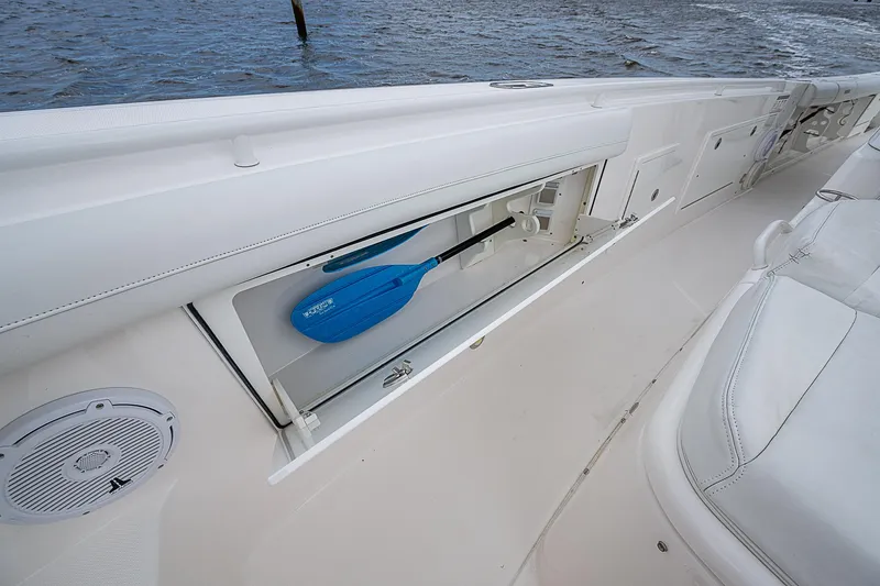 Riptide Yacht Photos Pics 2018 Everglades 435 Center Console boat with storage compartment and paddle, near water.