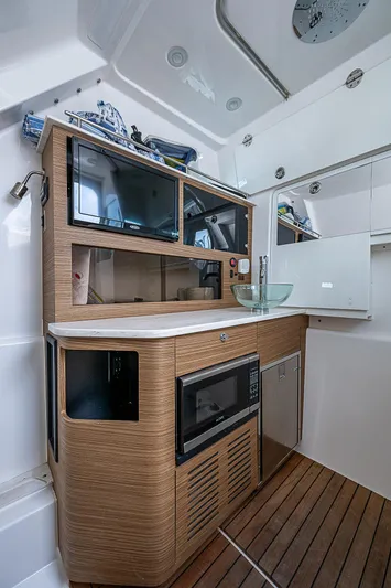 Riptide Yacht Photos Pics 2018 Everglades 435 Center Console interior with modern kitchenette and wood flooring.