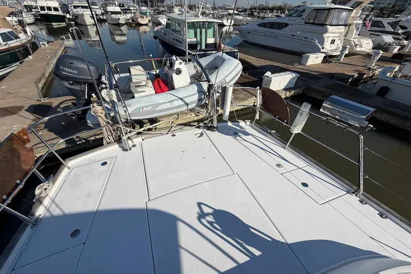 Nae Hassle Yacht Photos Pics Beneteau 57 yacht deck with dinghy and Yamaha motor, docked at marina, 2004 model.