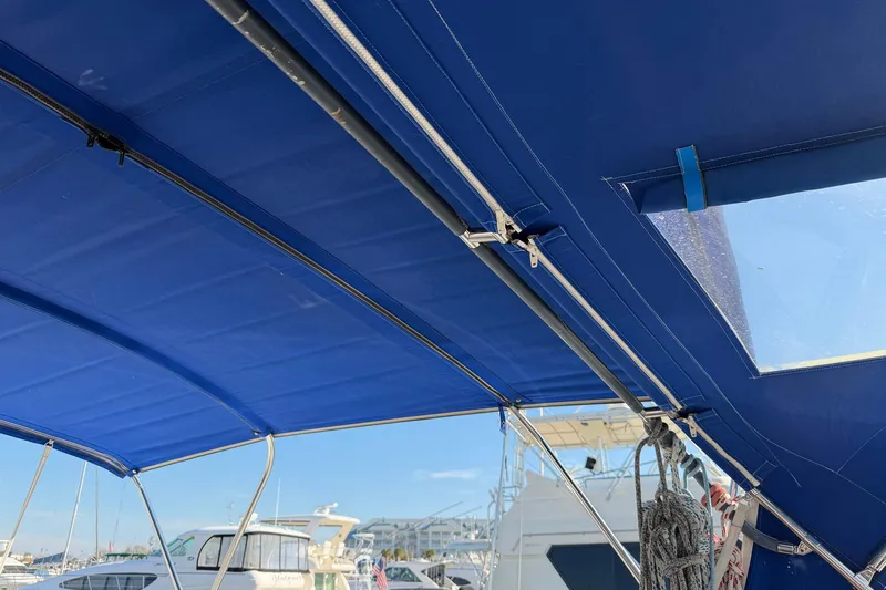 Nae Hassle Yacht Photos Pics Blue canopy on a 2004 Beneteau 57 sailboat, docked at a marina.