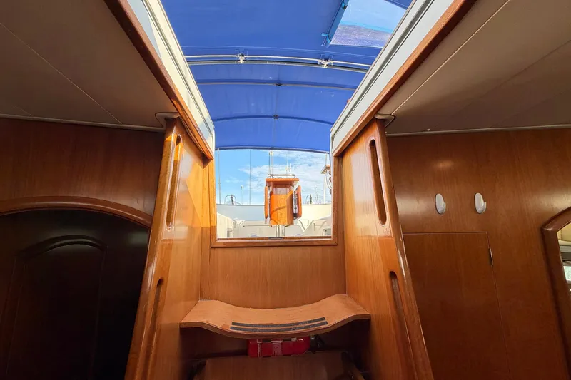 Nae Hassle Yacht Photos Pics Interior view of 2004 Beneteau 57 sailboat with wooden finish and blue canopy.