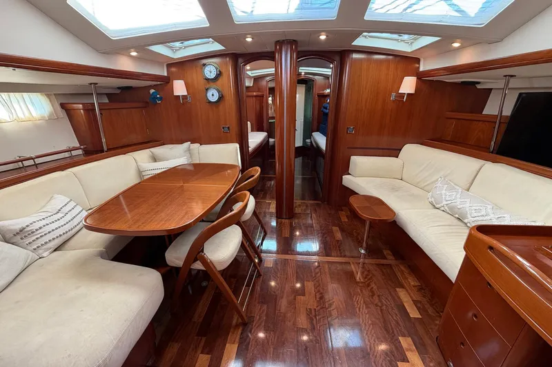 Nae Hassle Yacht Photos Pics Luxurious interior of 2004 Beneteau 57 yacht with elegant wood finish and comfortable seating.