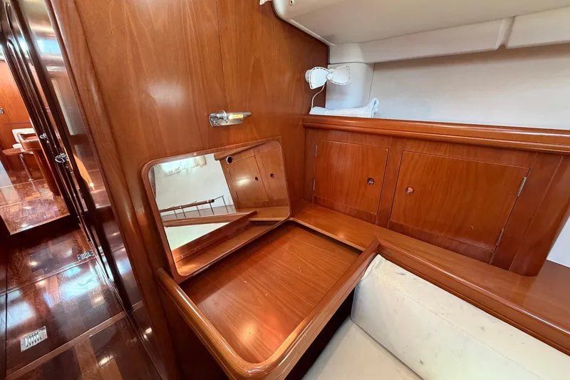 Nae Hassle Yacht Photos Pics Luxurious wooden interior of 2004 Beneteau 57 yacht with mirror and storage cabinets.