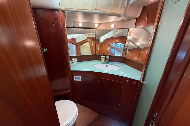 Nae Hassle Yacht Photos Pics Luxurious bathroom interior of 2004 Beneteau 57 yacht with wood finish and modern amenities.