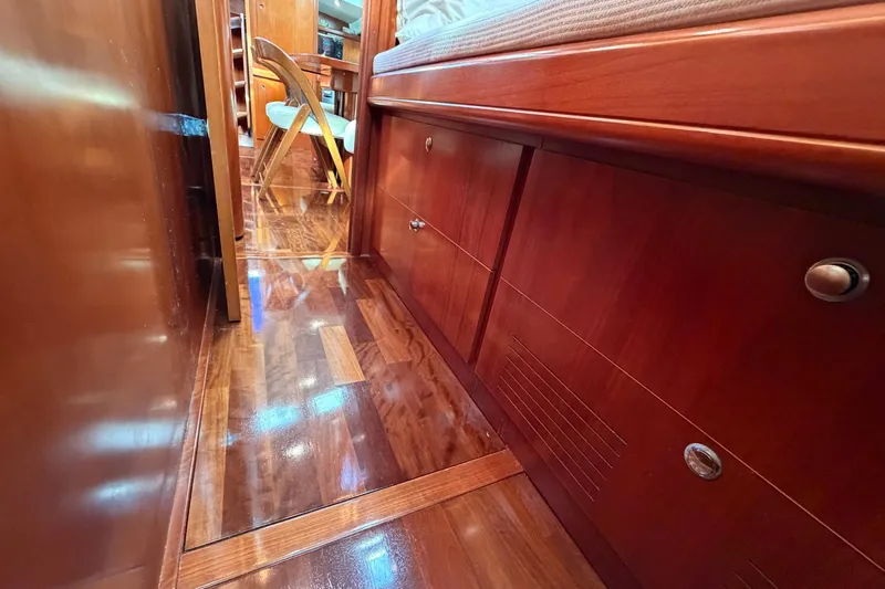 Nae Hassle Yacht Photos Pics Luxurious wooden interior of 2004 Beneteau 57 yacht, featuring polished floors and cabinetry.