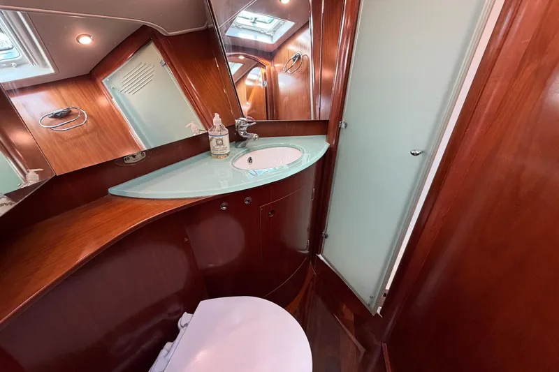 Nae Hassle Yacht Photos Pics Luxurious bathroom in 2004 Beneteau 57 yacht with wood finish and modern fixtures.
