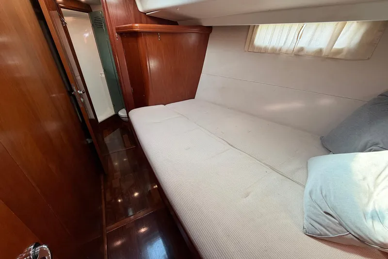 Nae Hassle Yacht Photos Pics Luxurious cabin interior of 2004 Beneteau 57 yacht with cozy bed and wooden finish.