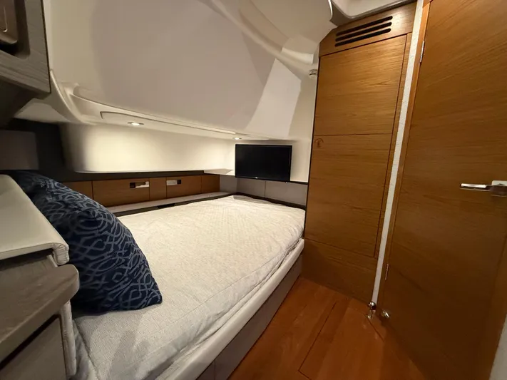  Yacht Photos Pics 2023 Tiara Yachts 43 LS cabin interior with bed, TV, and wooden accents.