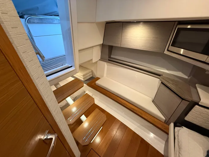 Yacht Photos Pics 2023 Tiara Yachts 43 LS interior with wooden steps, modern seating, and sleek cabinetry.
