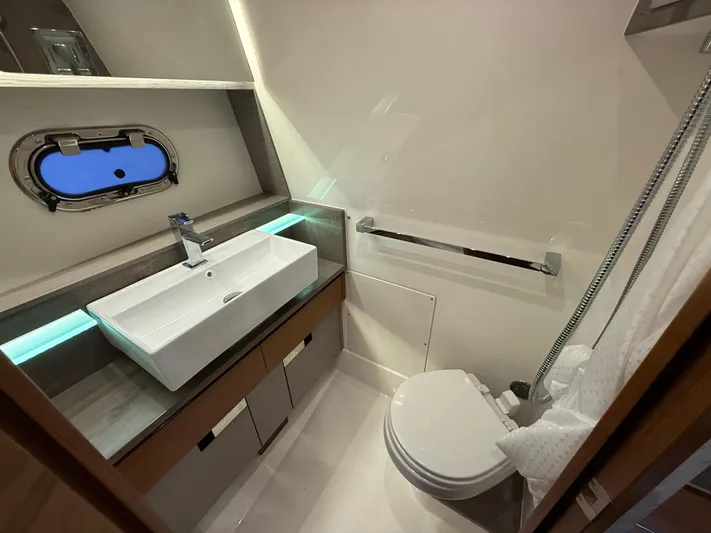  Yacht Photos Pics 2023 Tiara Yachts 43 LS bathroom with modern sink, toilet, and porthole window.