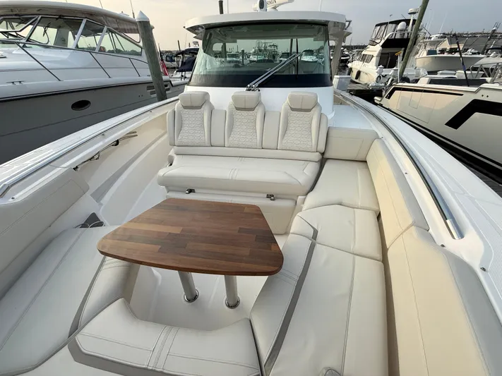  Yacht Photos Pics 2023 Tiara Yachts 43 LS with luxurious seating and wooden table in a marina setting.