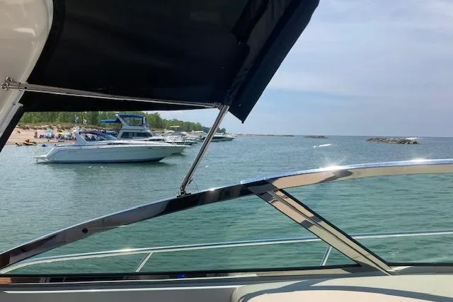 Lyman Zerga Yacht Photos Pics 2001 Sea Ray 380 Sundancer on tranquil waters near a sandy beach.