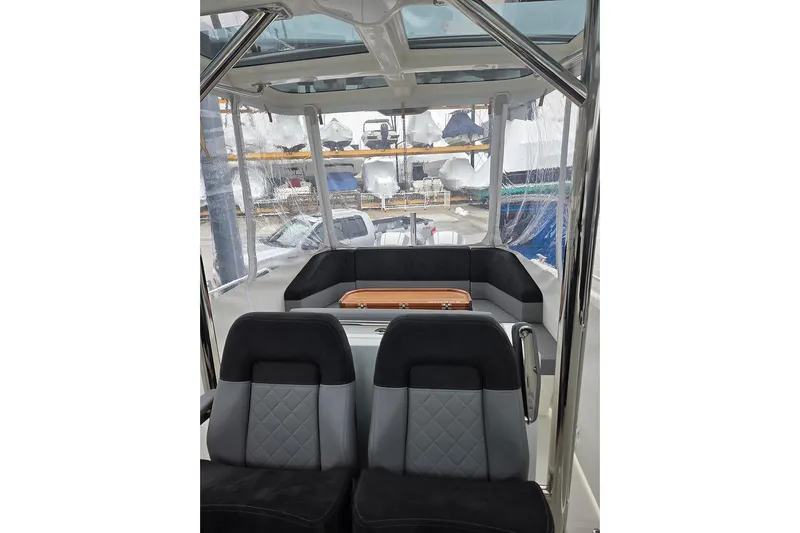 Ann #121 Yacht Photos Pics Interior view of 2023 Nimbus T9 boat with modern seating and clear canopy.