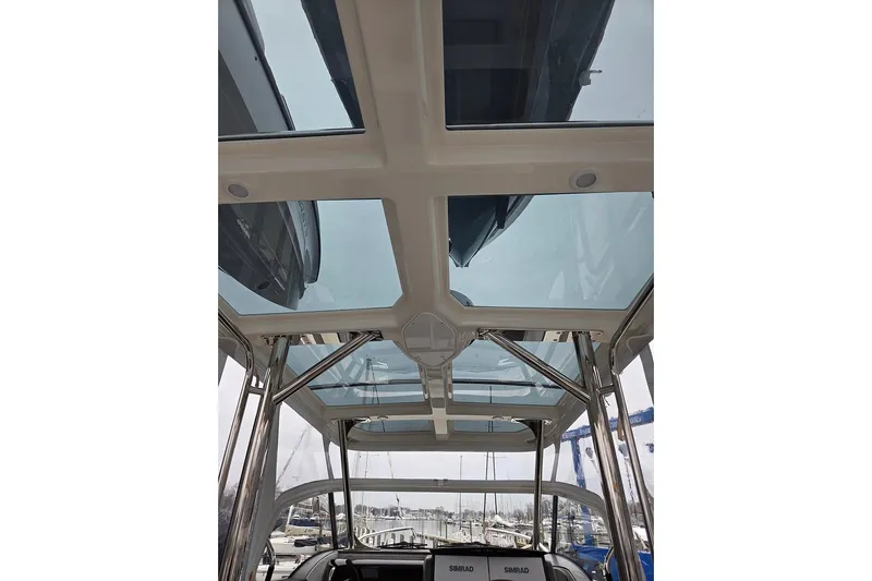 Ann #121 Yacht Photos Pics 2023 Nimbus T9 boat with glass roof and stainless steel supports at a marina.