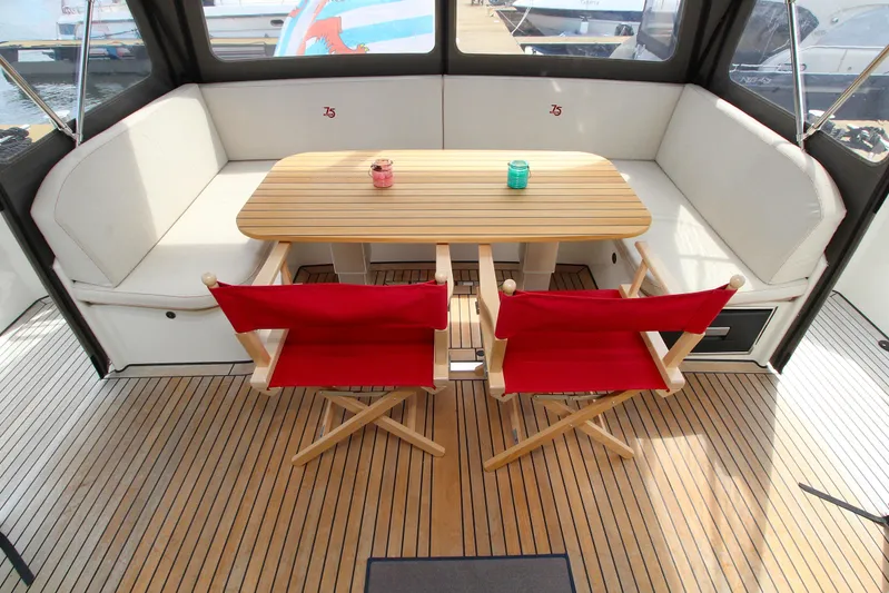  Yacht Photos Pics Luxurious 2024 Linssen 55 SL AC Variotop yacht interior with wooden table and red chairs.