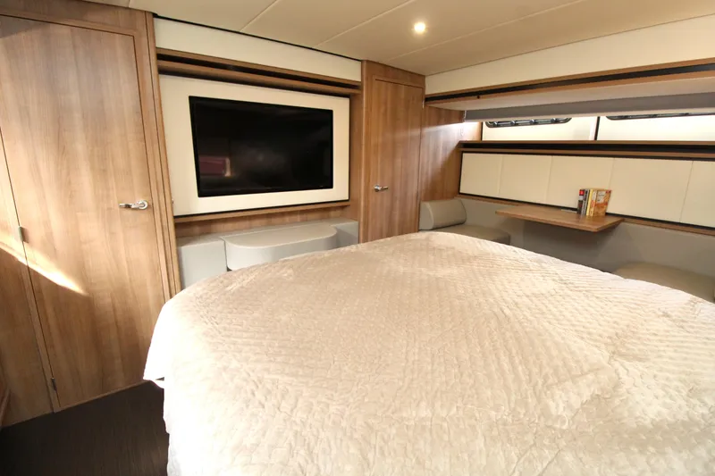  Yacht Photos Pics Luxurious bedroom interior of 2024 Linssen 55 SL AC Variotop yacht with TV and wood accents.