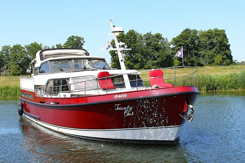  Yacht Photos Pics 2024 Linssen 55 SL AC Variotop yacht cruising on a serene waterway.