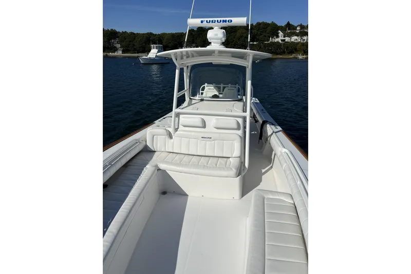 34 #025 Yacht Photos Pics 2011 Regulator 34SS boat with white seating, docked on calm water.