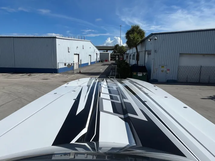  Yacht Photos Pics MTI 52RP 2018 boat with sleek design in industrial area under blue sky.