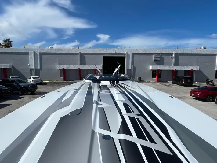  Yacht Photos Pics MTI 52RP 2018 boat with sleek design in front of industrial building.