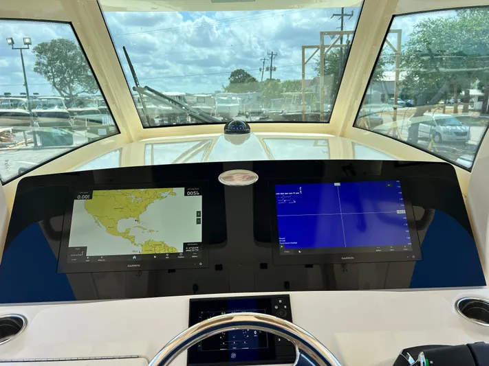  Yacht Photos Pics 2025 Scout 357 LXF boat dashboard with dual navigation screens and steering wheel.