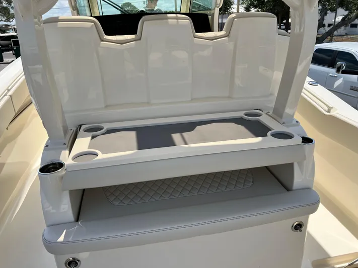  Yacht Photos Pics 2025 Scout 357 LXF boat seating area with cup holders and storage.