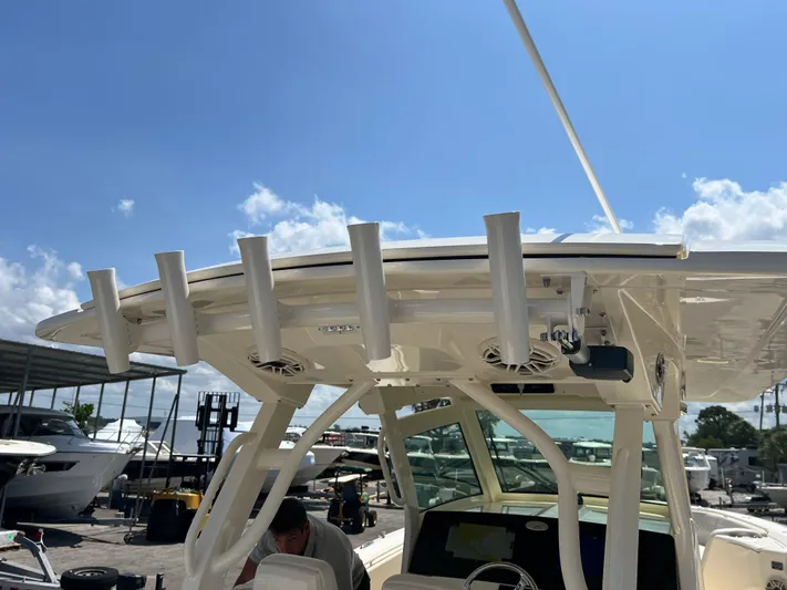  Yacht Photos Pics 2025 Scout 357 LXF boat with rod holders and canopy under a clear blue sky.
