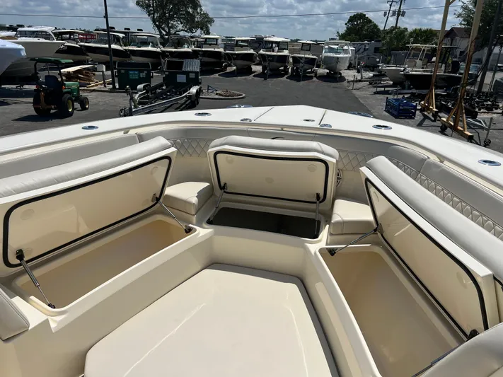  Yacht Photos Pics 2025 Scout 357 LXF boat with open storage compartments, docked in a marina.