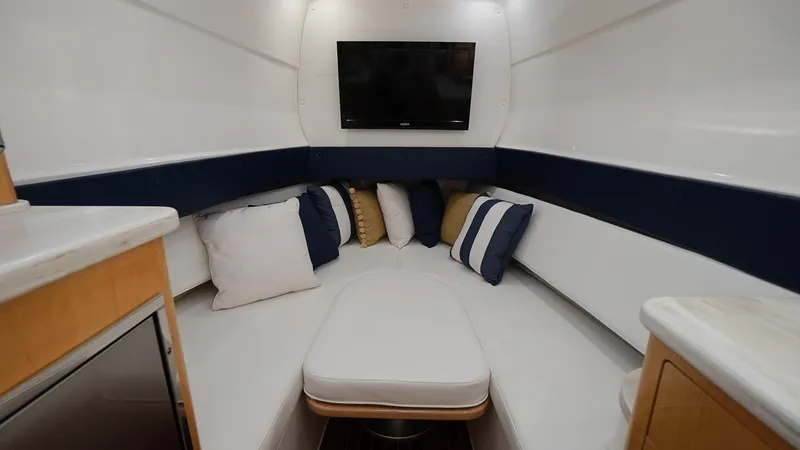 Audacious Yacht Photos Pics Interior cabin of 2016 Intrepid 475 Panacea with seating, pillows, and TV.