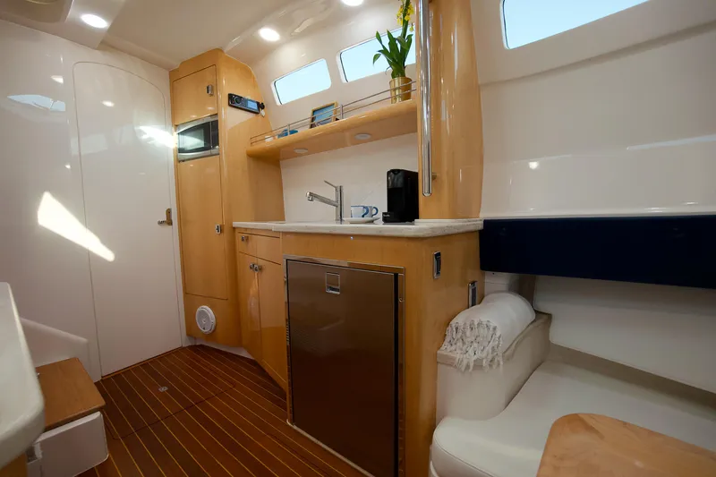 Audacious Yacht Photos Pics 2016 Intrepid 475 Panacea interior with modern kitchen, wooden cabinetry, and natural light.