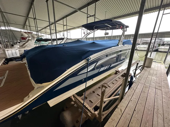  Yacht Photos Pics 2016 Sea Ray SDX 290 boat docked under covered marina, blue cover, side view.