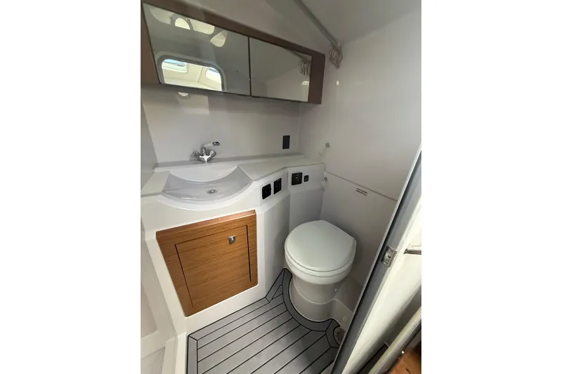 Yacht Photos Pics 2019 Cruisers Yachts 338 Outboard bathroom with sink, toilet, and wood accents.