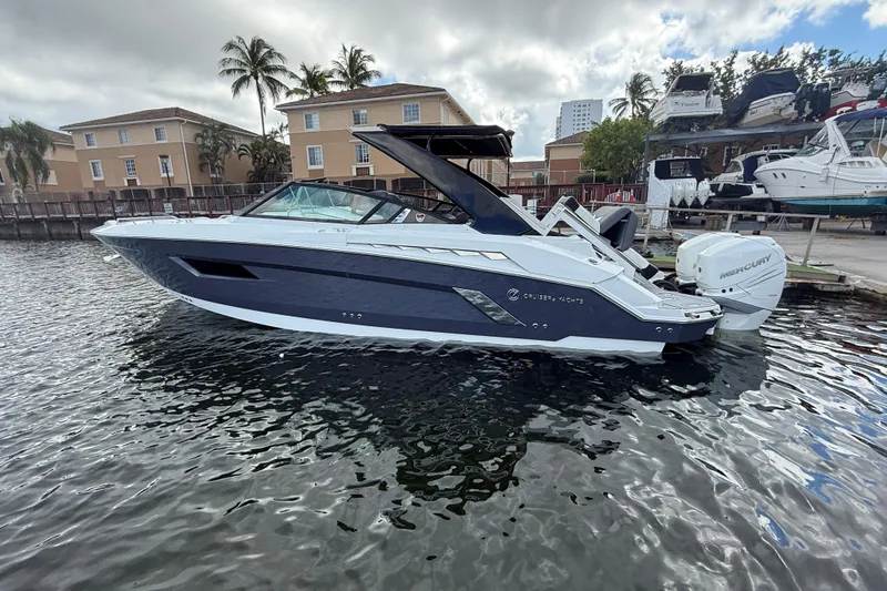  Yacht Photos Pics 2019 Cruisers Yachts 338 Outboard in marina, sleek design, palm trees in background.