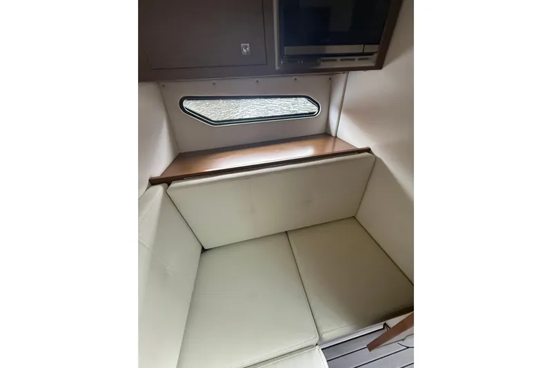  Yacht Photos Pics 2019 Cruisers Yachts 338 Outboard interior with cushioned seating and window view.