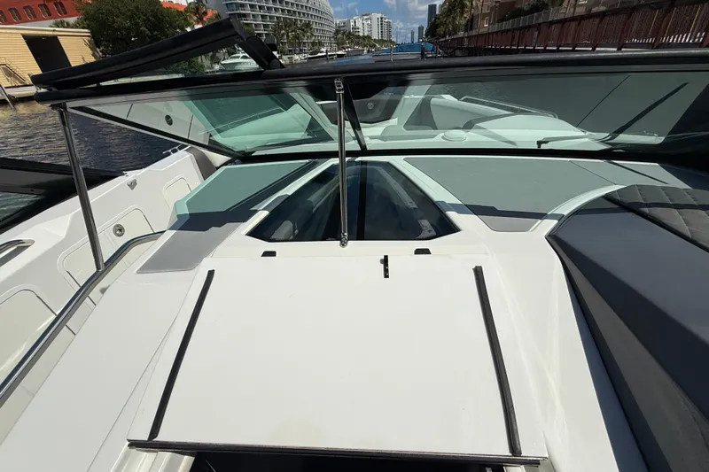  Yacht Photos Pics 2019 Cruisers Yachts 338 Outboard boat deck with open windshield, docked by waterfront.