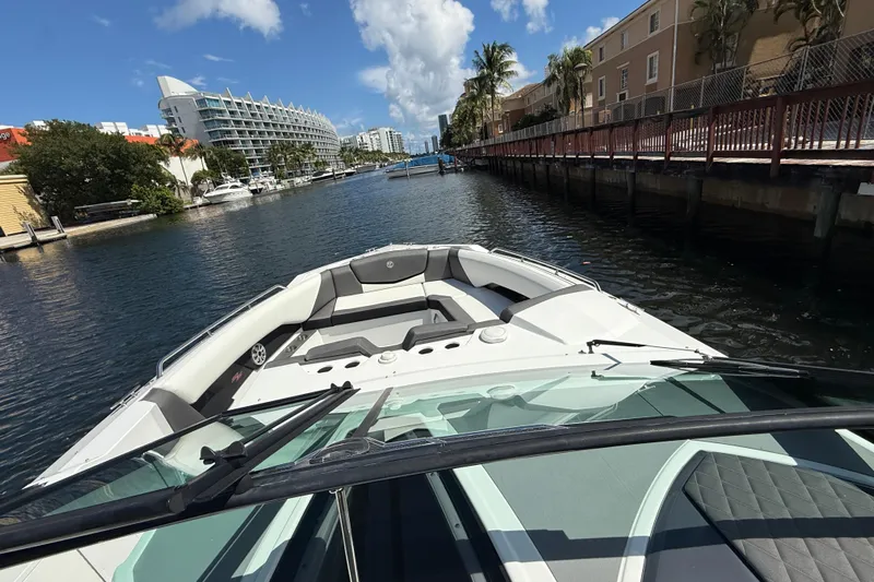  Yacht Photos Pics 2019 Cruisers Yachts 338 Outboard navigating a scenic canal with modern buildings.