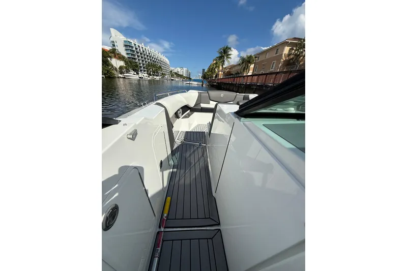  Yacht Photos Pics 2019 Cruisers Yachts 338 Outboard, sleek deck view, docked near waterfront buildings.