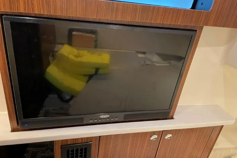  Yacht Photos Pics 2023 Pursuit S 358 Sport interior with mounted TV and wooden cabinetry.