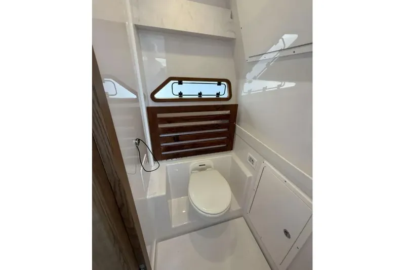  Yacht Photos Pics 2024 Bertram 39 CC boat bathroom with modern design and wooden accents.