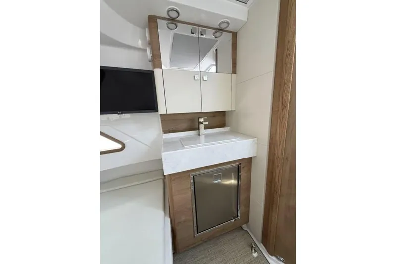  Yacht Photos Pics 2024 Bertram 39 CC bathroom with modern sink, mirror, and wood accents.