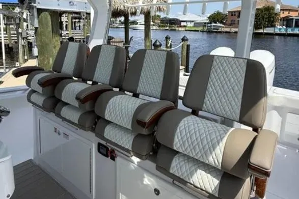  Yacht Photos Pics 2024 Bertram 39 CC boat seating with quilted upholstery, docked by a scenic waterfront.