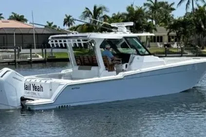  Yacht Photos Pics 2024 Bertram 39 CC boat on water, surrounded by palm trees and waterfront homes.